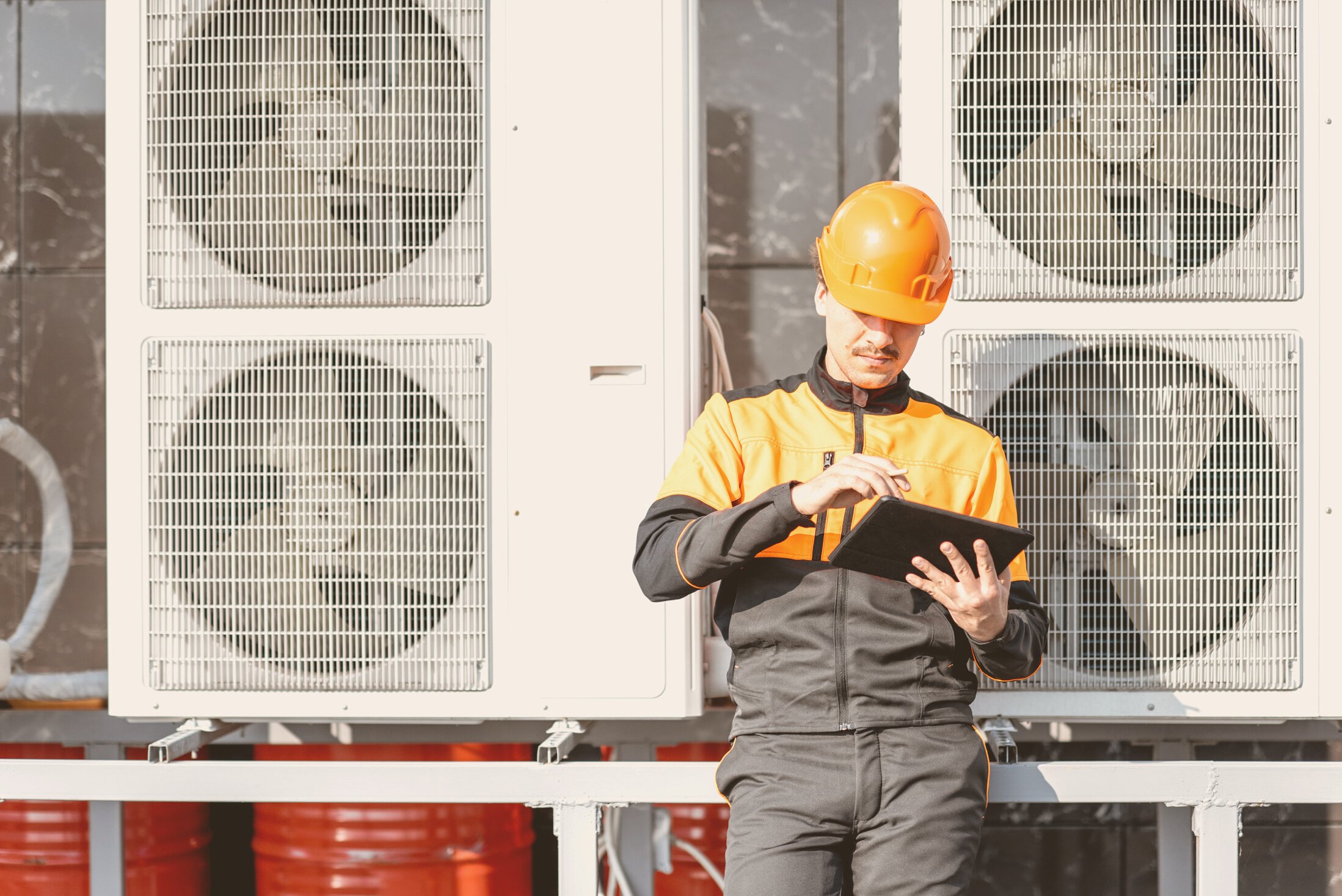 Workman Servicing Air Conditioning or Heat Pump with Digital Tablet