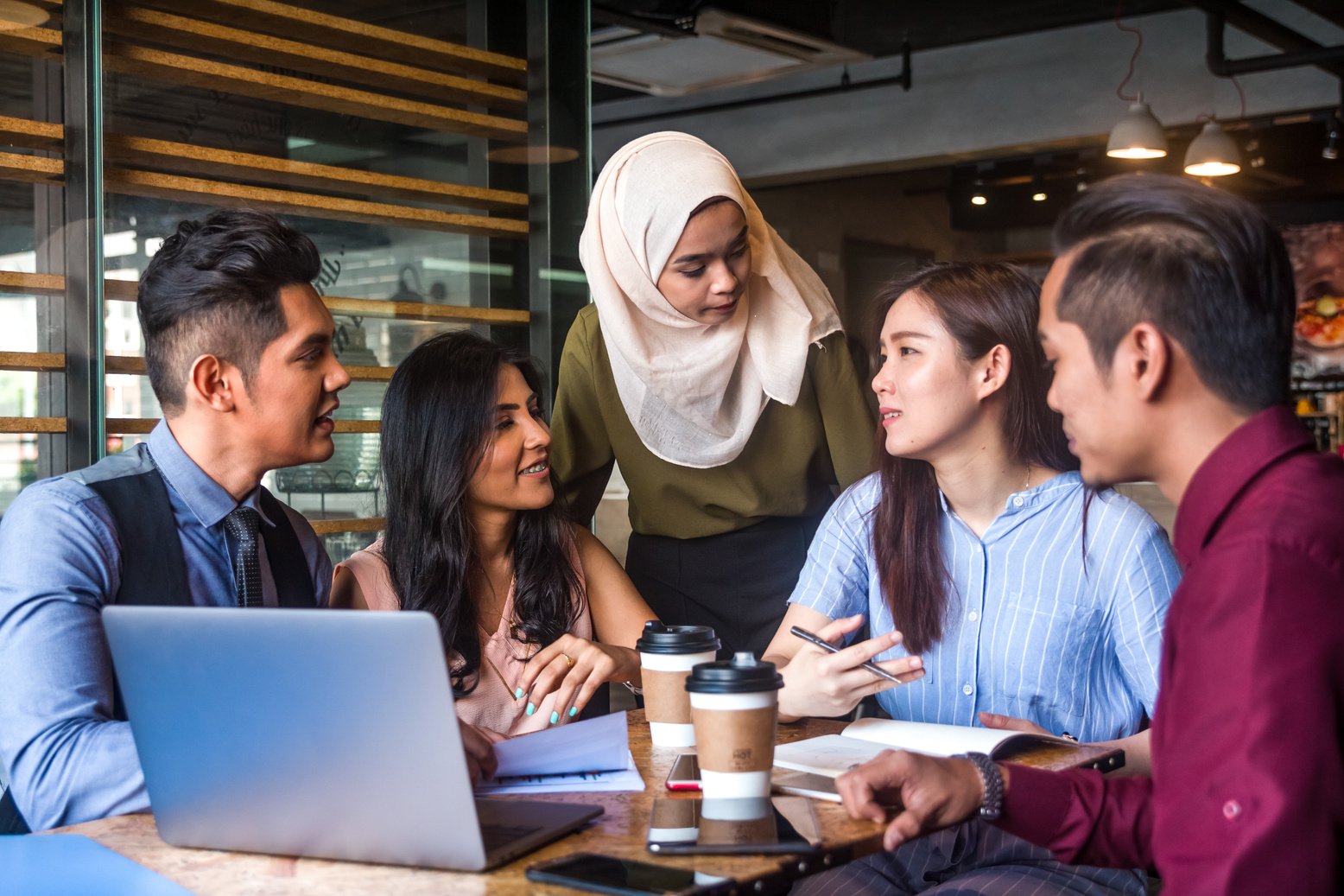 Muslim team leader encourage her team member during a business meeting